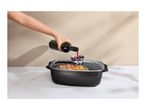 Pouring red wine into the aroma knob of a glass lid on a black roasting pan
