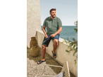 LIVERGY Herren Pantolette Sandalen, Poloshirt und Jeans-Shorts, Mann sitzt am Meer