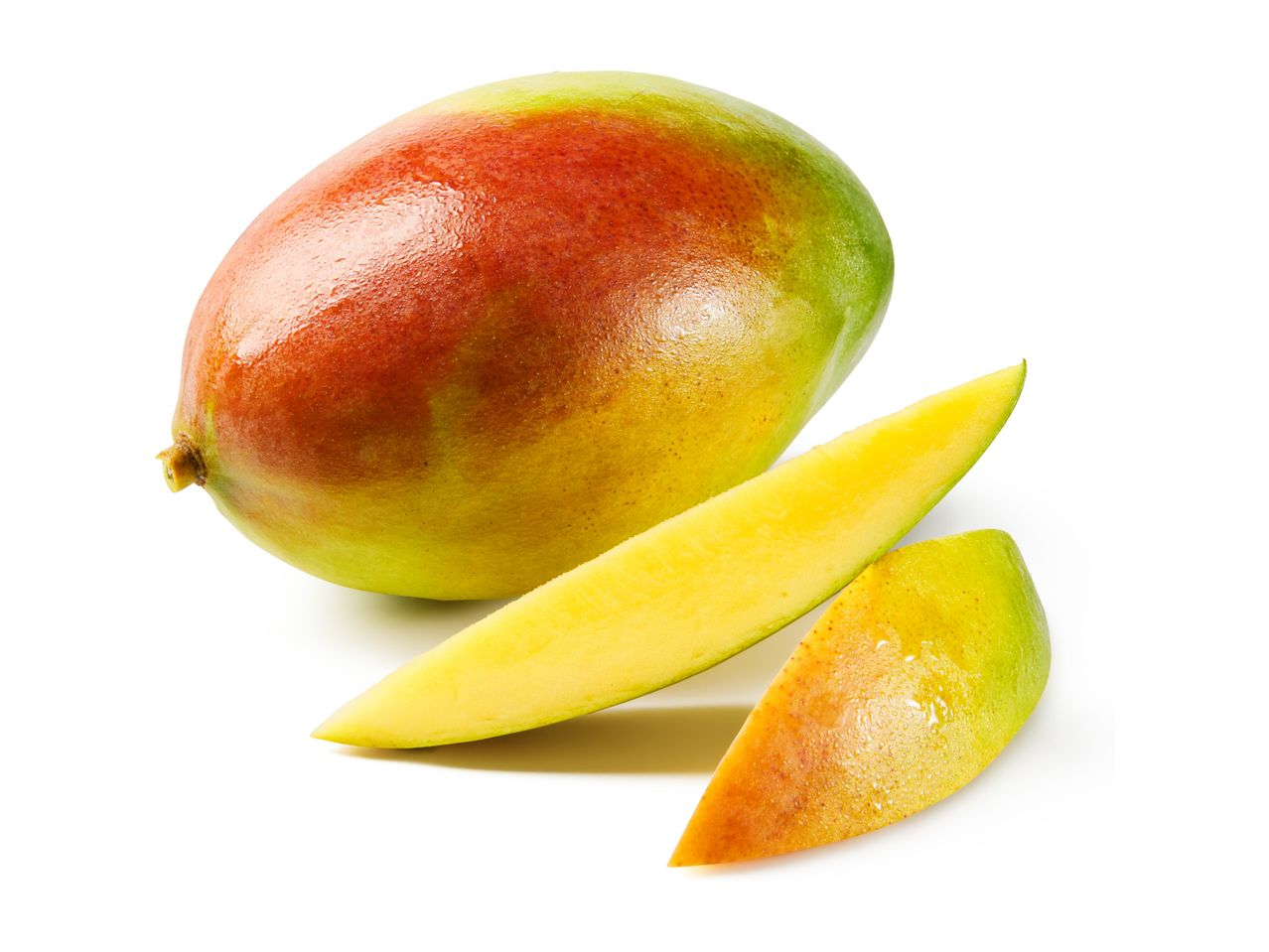 Whole mango and two mango slices with water droplets on a white background.