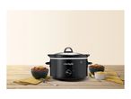 A black slow cooker on a wooden table next to bowls of chili.