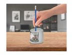 A hand inserts a blue pencil into a grey electric pencil sharpener on a wooden table.
