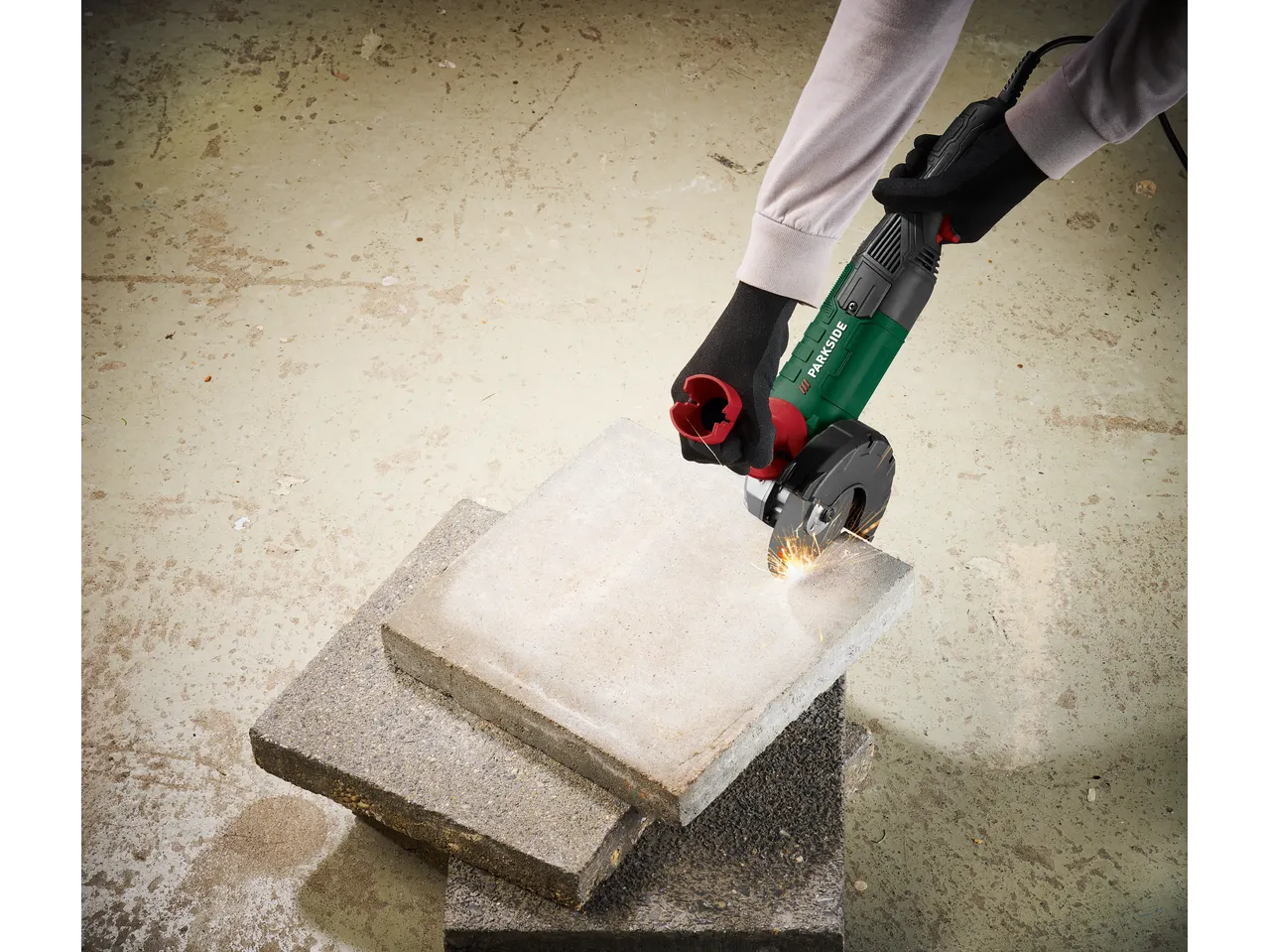 Person cutting a slab with a Parkside Performance® PWS 125 angle grinder.