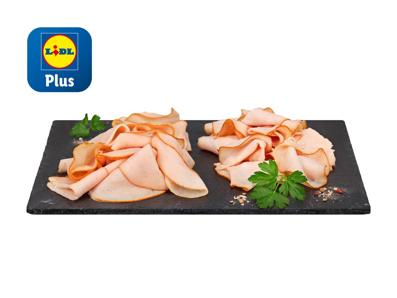 LIDL Plus: Zwei Stapel gebratenen Putenbrustscheiben auf schwarzem Schieferstein.