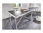Three folding wallpapering tables with wallpaper, a brush, and a bucket with tools.