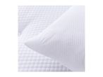 Close-up of a white quilted pillow and mattress protector.