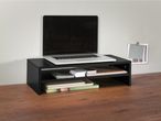 A black laptop stand with two shelves holds a laptop and office supplies on a wood desk.