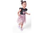 A girl joyfully leaps in a Paw Patrol-themed dress and white sneakers.