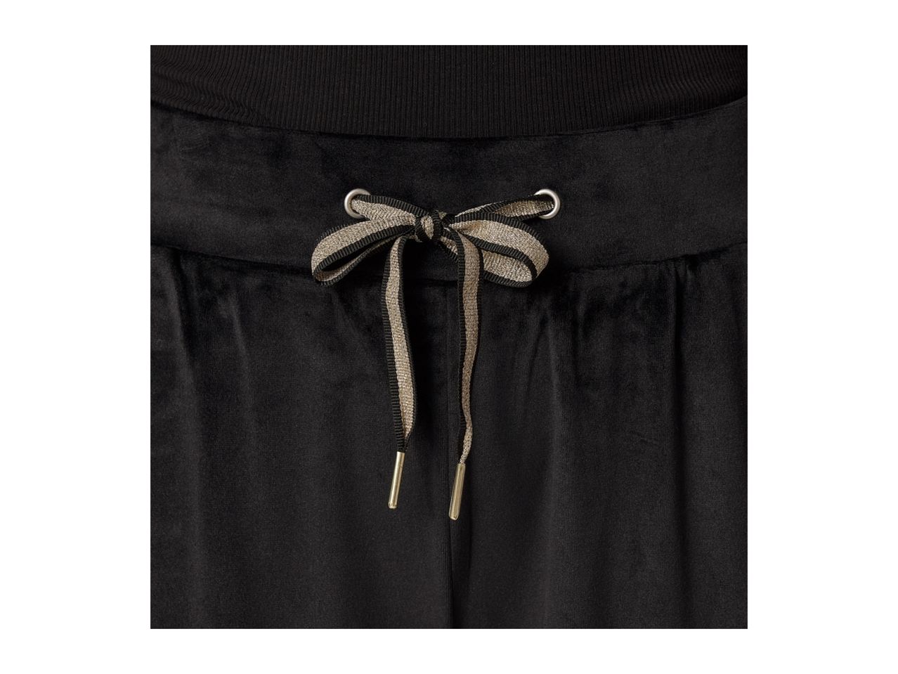 Close-up of black velvet sweatpants with a gold and black striped drawstring bow.