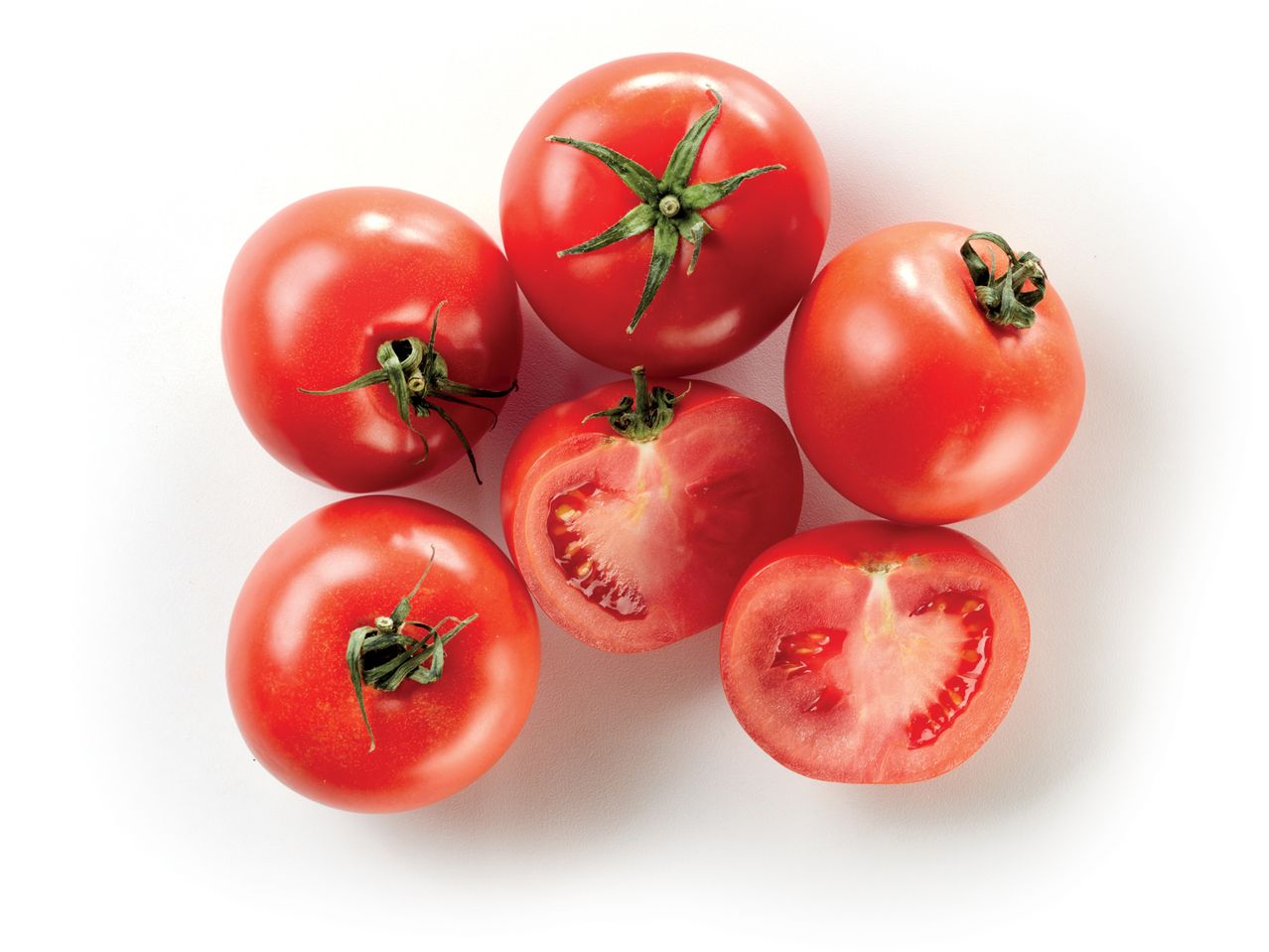 Five red tomatoes, one halved, arranged on a white background.