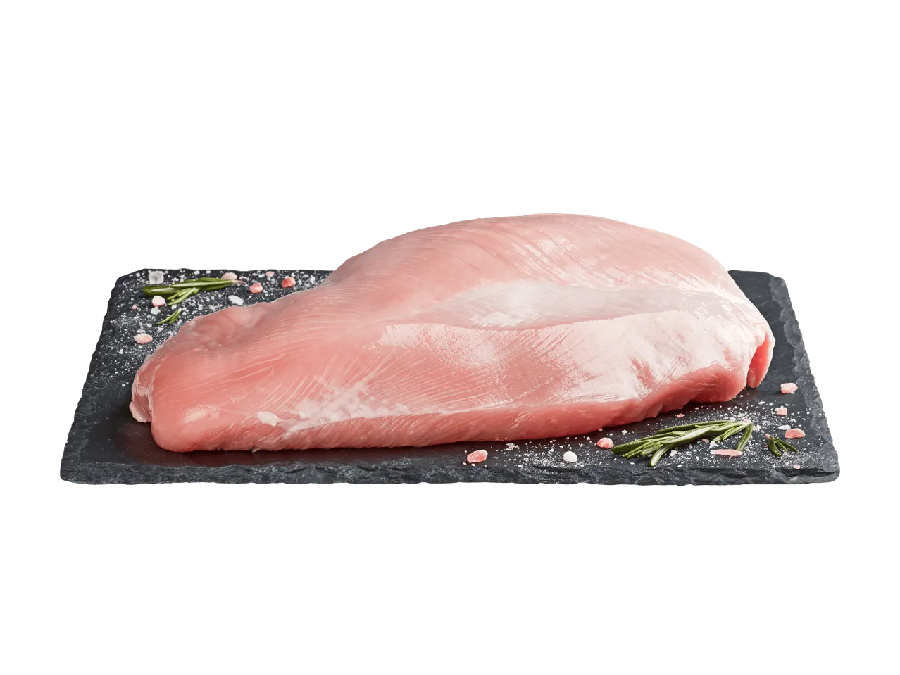 Petto di tacchino fresco su una lastra di ardesia con rosmarino e sale.