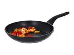 Black frying pan with cooked shrimp, cherry tomatoes, and herbs.