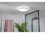 Um moderno plafonnier redondo ilumina um banheiro elegante.