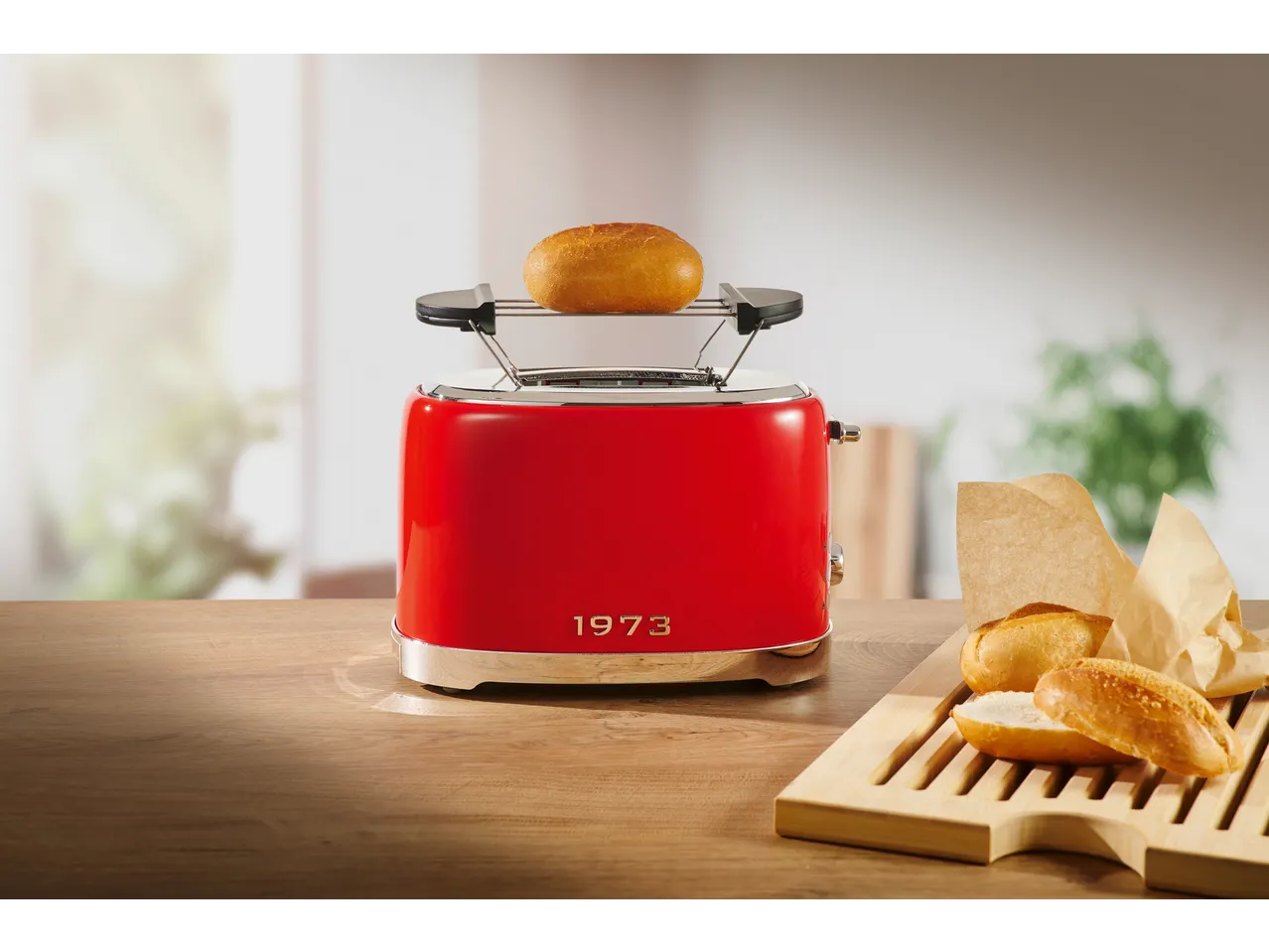 SILVERCREST® 2-Slice Toaster in red with a bun on top, next to bread rolls.