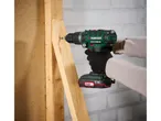 Un uomo utilizza un trapano a percussione Parkside X20V Team per fissare un pezzo di legno.