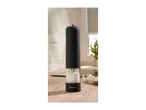 Black electric salt grinder with visible salt crystals on a wooden kitchen counter.