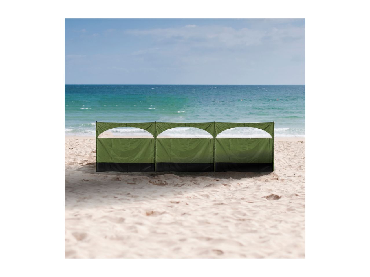 Green beach windbreak with three sections on a sandy beach with the ocean in the background.