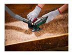 Hands in grey gloves using a multi-sander with dust extraction on a wooden surface.