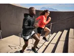 Dois atletas correm escadas acima, usando sapatilhas de corrida Crivit.