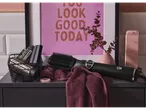 Cien Beauty rotating hot air brush on a towel, with accessories in a basket.