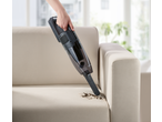 Silvercrest „2 u 1“ bežični usisivač čisti prljavštinu sa sofe.