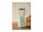 Mint green blender with a glass jug on a wooden counter against a tiled wall.