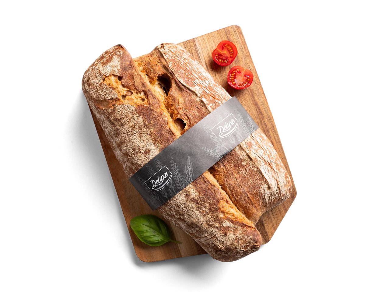 Deluxe ciabatta kenyér paradicsommal és bazsalikommal egy vágódeszkán