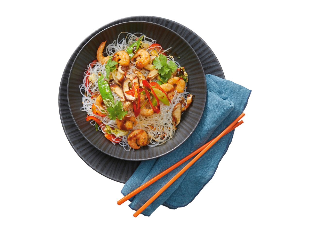 Glass noodle stir-fry with prawns, mushrooms, and vegetables, served in a dark bowl with chopsticks.