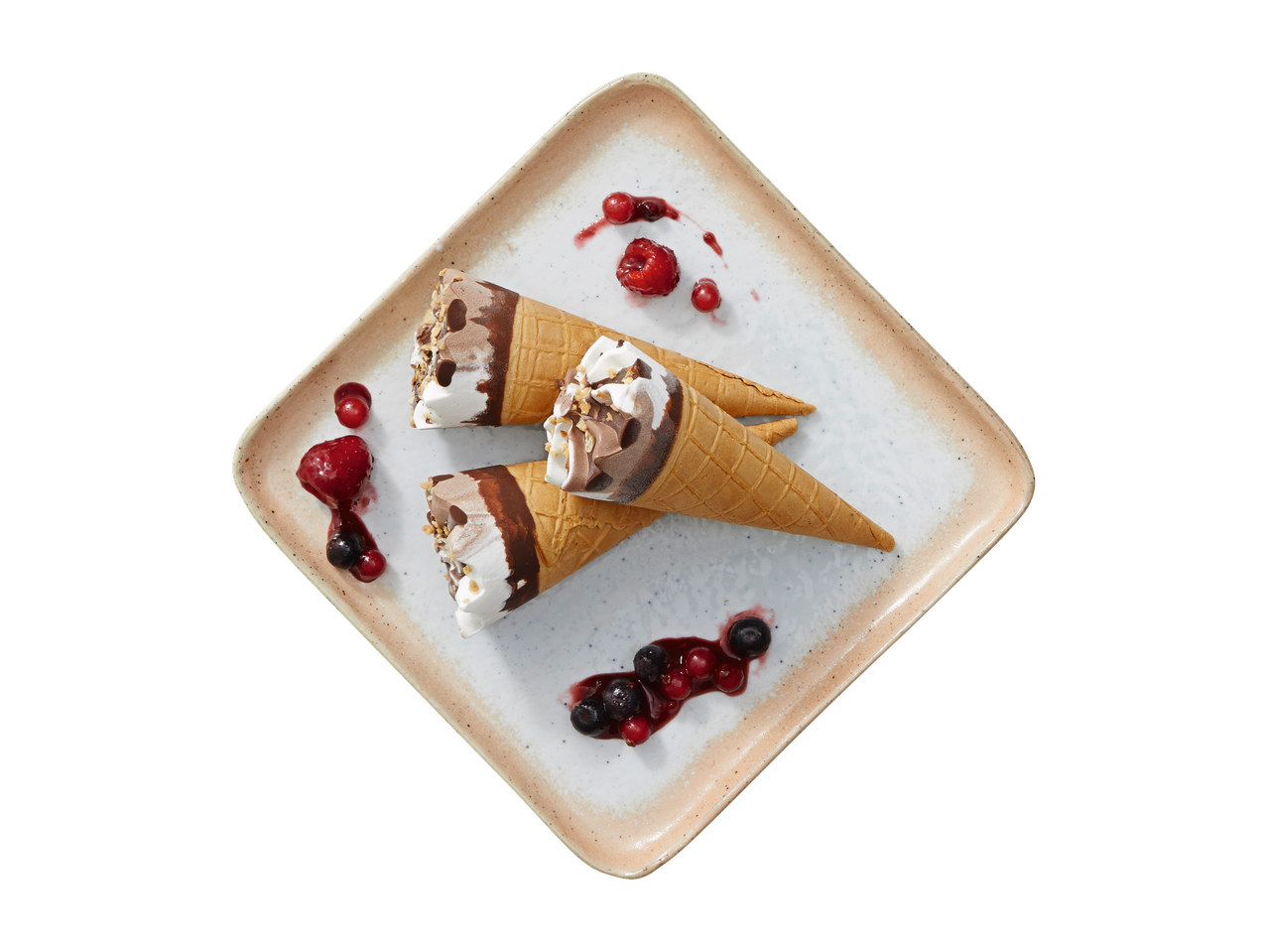 Três cones de sorvete com frutas vermelhas em um prato quadrado.