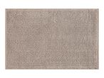 A beige, textured bath mat with a looped pile.