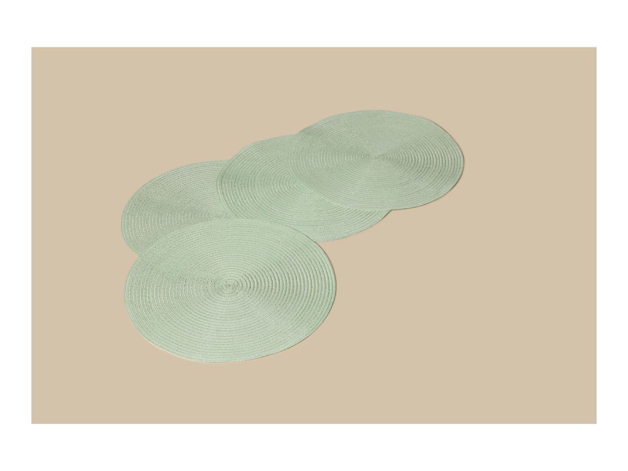 Four light green round placemats arranged diagonally on a beige background.