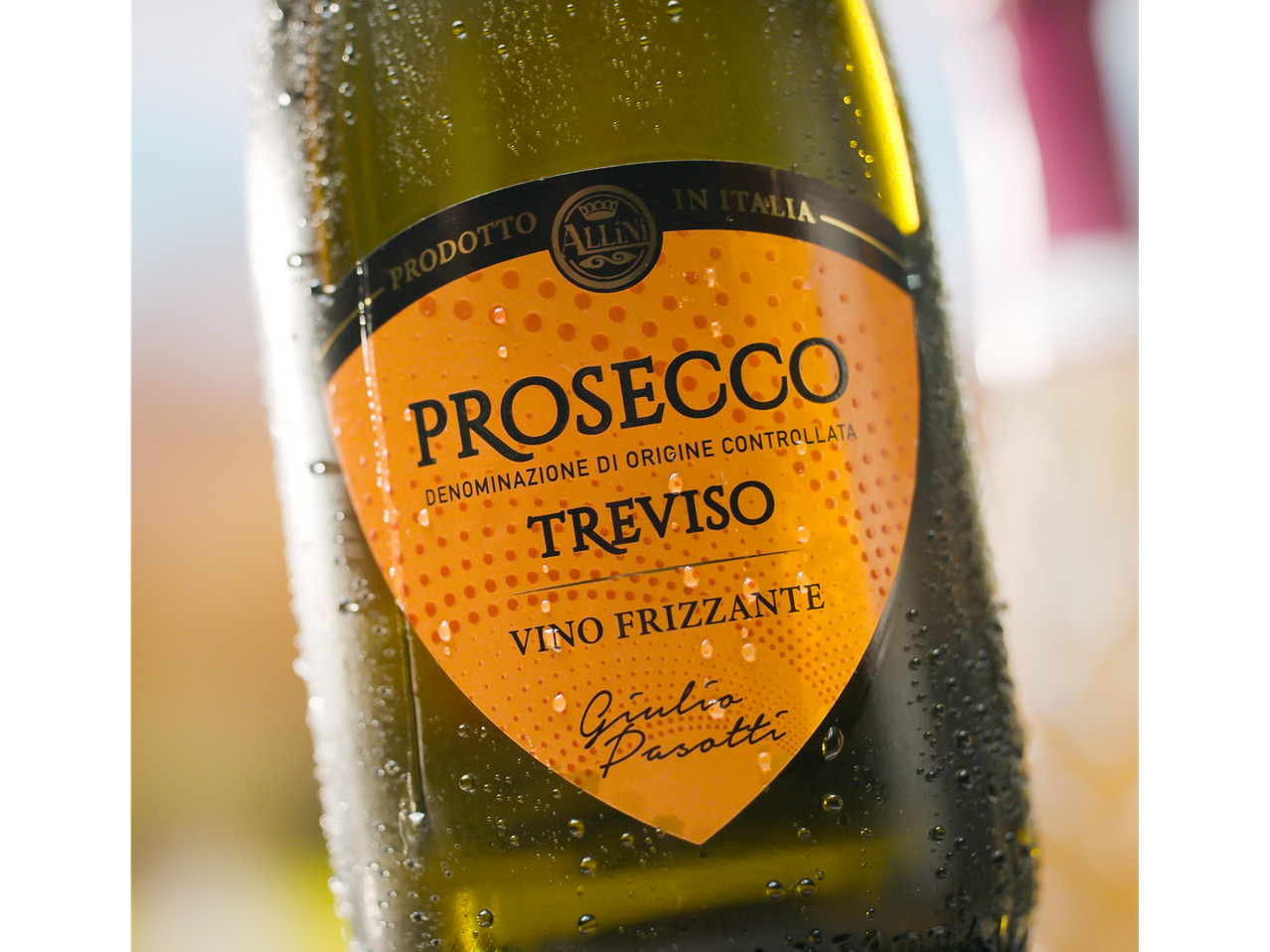Chilled bottle of Allini Prosecco Treviso, with condensation and an orange label.
