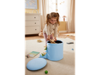 Menina brincando com brinquedos de madeira e caixa organizadora azul em formato de dinossauro.