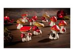 Mushroom figurines and candles on a wooden surface.