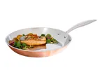 Copper frying pan with cooked salmon, roasted potatoes, and a fresh salad.