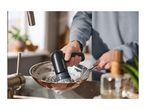 Person washing a pan with a dish brush in a kitchen sink.