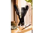 Cien Beauty: escovas e pentes pretos num recipiente de vidro, com produtos de beleza.
