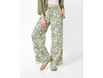 Pantaloni largi de damă ESMARA cu model floral verde, asortați cu o cămașă verde și adidași bej.
