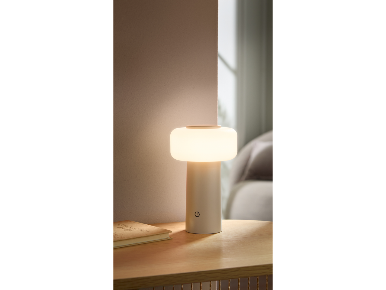 LIVARNO home batterijgevoede LED-tafellamp op een houten tafel met een boek.