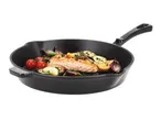A black cast iron pan with cooked salmon, cherry tomatoes, zucchini, potatoes, and red onions.