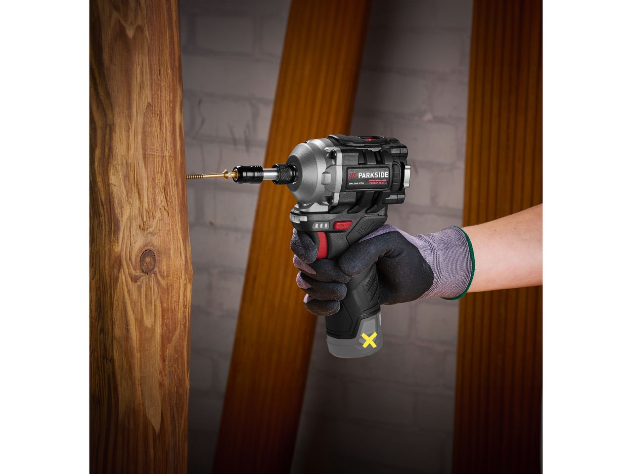 Un Avvitatore a percussione Parkside avvita una vite in un pezzo di legno.