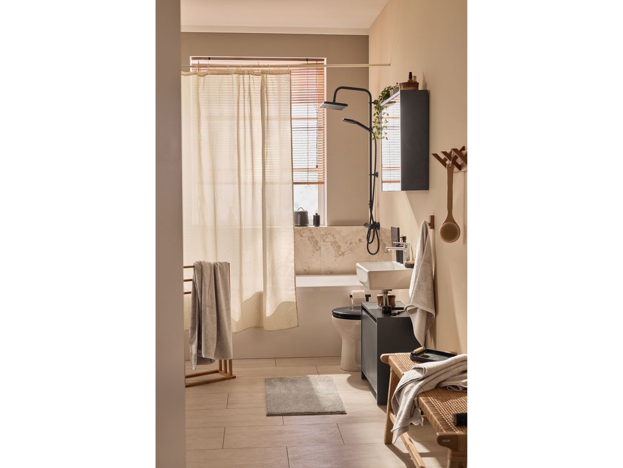 Bagno moderno e minimalista con doccia a soffitto, lavabo e mobiletto.
