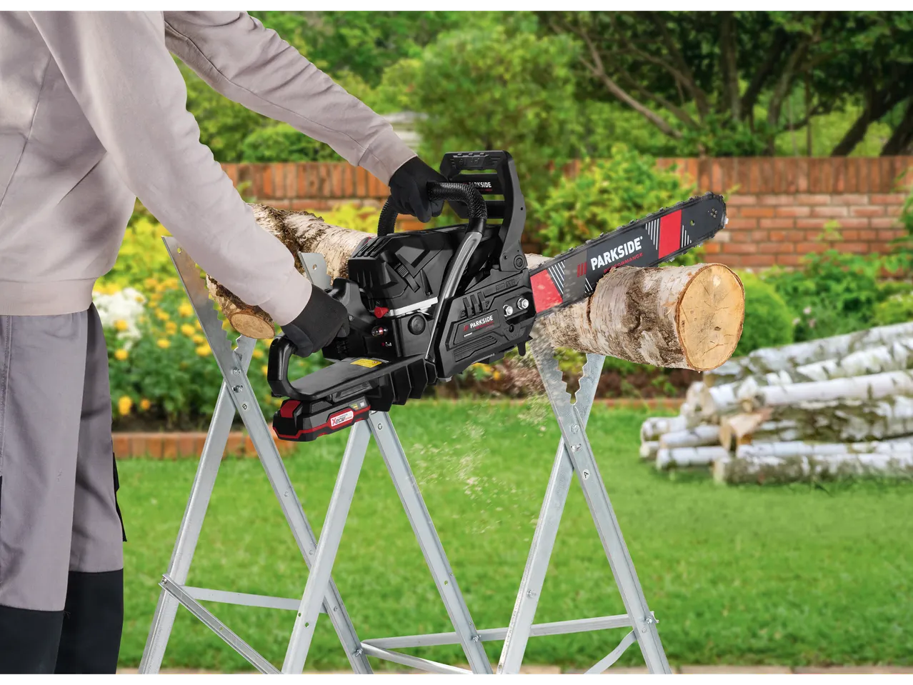 A man uses a Parkside chainsaw to cut wood.