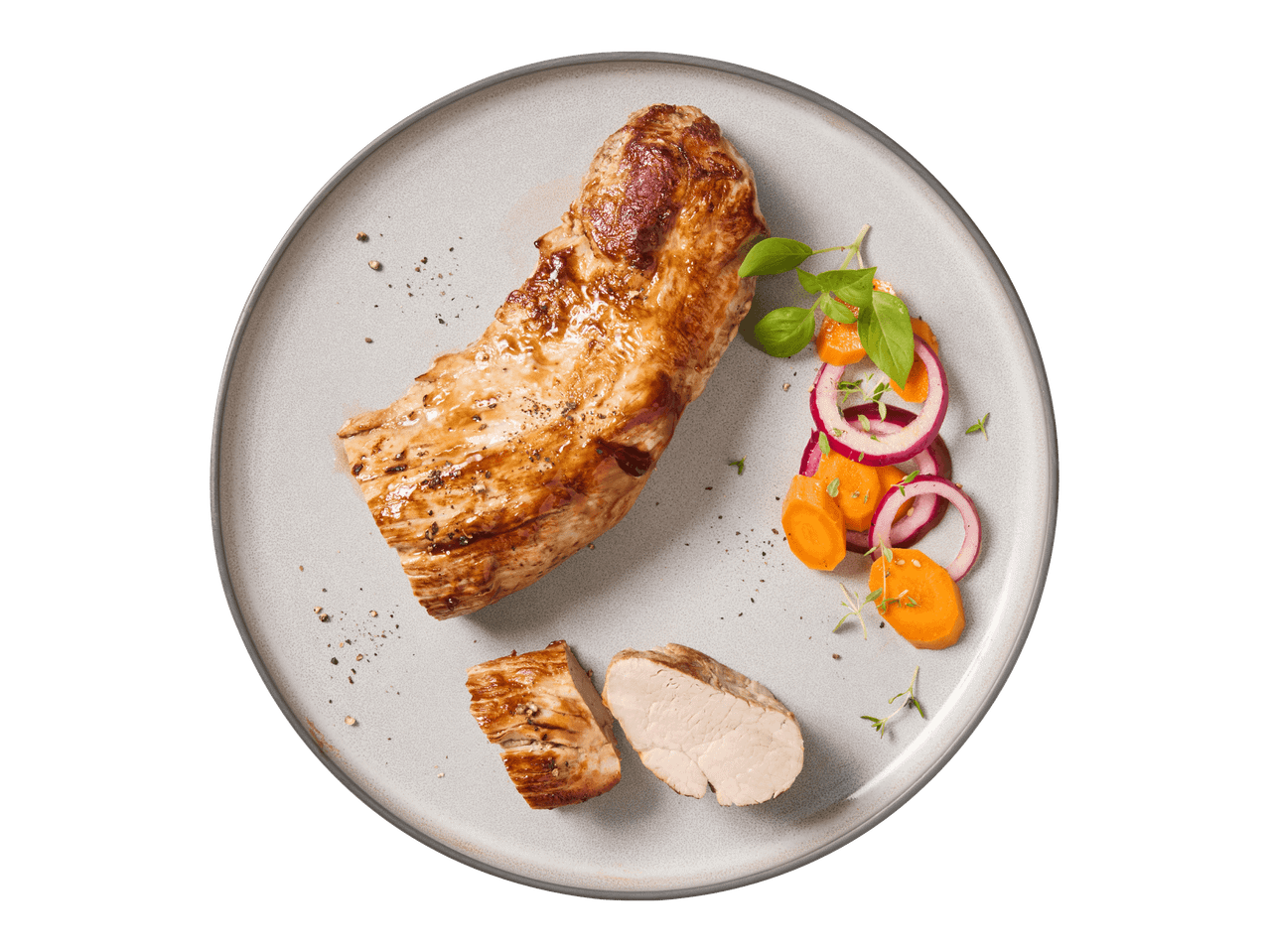 Grillattua porsaan sisäfileetä, porkkanoita, punasipulia ja yrttejä lautasella.