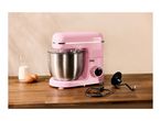 A pink SilverCrest stand mixer with a stainless steel bowl, milk, and eggs on a wooden counter.