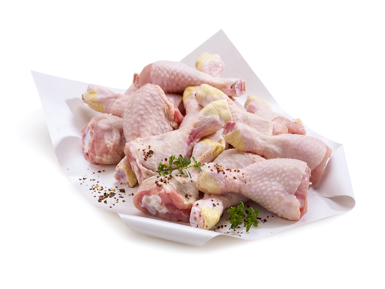 Pilons et hauts de cuisse de poulet crus avec herbes et épices sur papier blanc