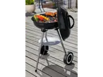 Charcoal grill with sausages and vegetable skewers.