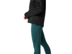 En kvinna i en svart softshelljacka och mörkgröna leggings.