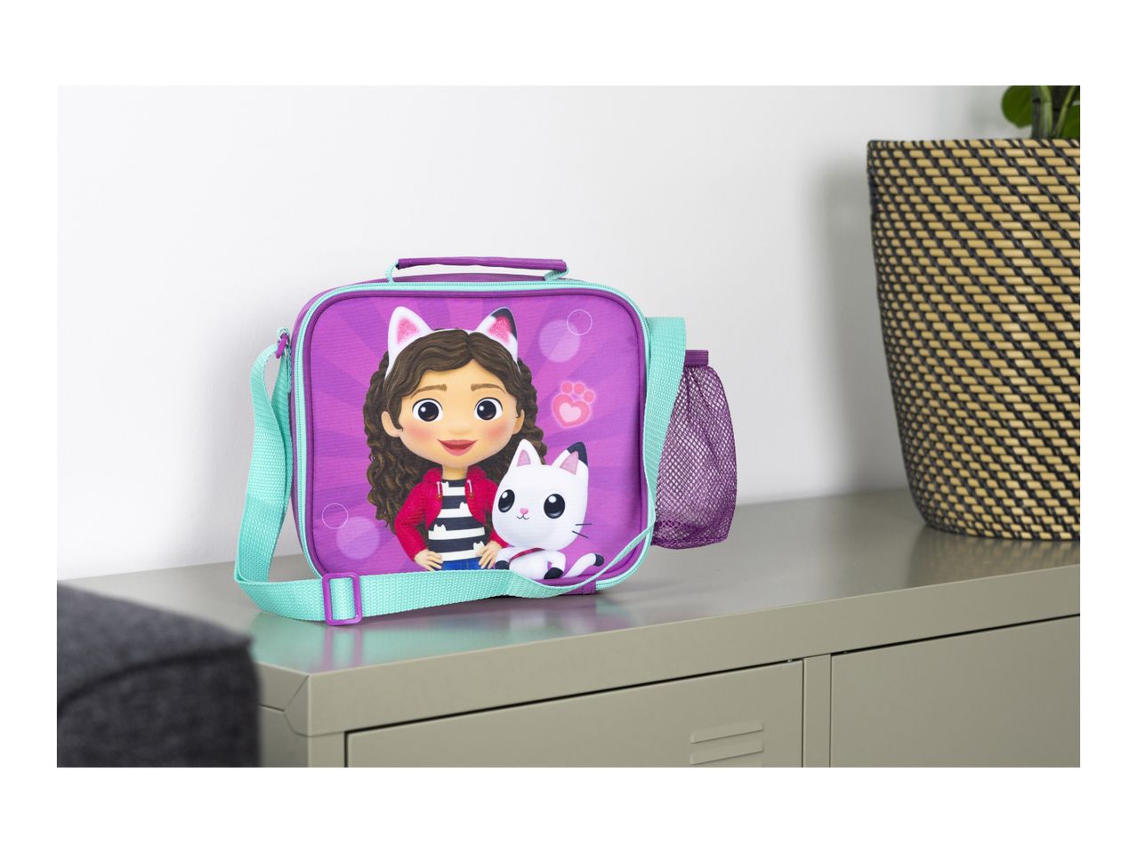 Purple lunch bag with a cartoon girl and white cat, featuring a turquoise strap.