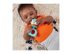 Baby lying on a rug, playing with a colorful animal-shaped rattle.