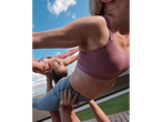 Mulheres em leggings desportivas CRIVIT e soutiens desportivos a praticar acroyoga ao ar livre.